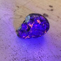 Crâne en Yooperlite (pierre de lumière) 8 cm - pierre unique dans le monde - photo sous lampe bleu - boutique pierre du monde La Porte des Secrets